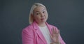 Slow motion portrait of unhappy Asian businesswoman clapping hands without enthusiasm feeling obliged on gray background