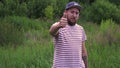 Slow motion portrait of young bearded funny man with cap OK hand gesture.