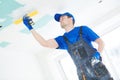 Refurbishment. Plasterer spackling a gypsum plasterboard ceiling with putty Royalty Free Stock Photo