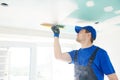 Refurbishment. Plasterer spackling a gypsum plasterboard ceiling with putty Royalty Free Stock Photo