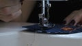 Slow motion. Seamstress lowers the presser foot of the sewing machine.