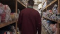 In slow-motion shooting, a guy man at a factory in a warehouse chooses different rolls of cloth worn in a work coat. Concept o
