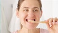 Slow motion shot of young woman brushing her teeth and looking in mirror. Concept of teeth health, self checking mouth and oral Royalty Free Stock Photo