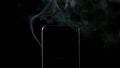 SLOW MOTION: Smoke goes out from smartphone on a black background