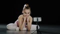 Slow motion teen girl ballerina child teenager gymnast dancer sitting on floor in dance class watching in mobile phone Royalty Free Stock Photo