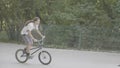 Teenager on the BMX doing triks in the park