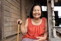 Slow-motion of Thai elderly woman in round-necked sleeveless collar laughing in wooden home