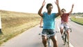 Slow motion of three young adults having fun cycling, graded