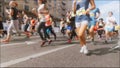 Slow motion unfocused video of marathoners run on street at hot sunny day