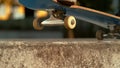 SLOW MOTION: Unrecognizable skater nose grinds a concrete ledge in the skatepark