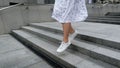 Slow motion video of happy young woman skipping and running down stone stairs