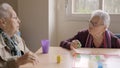 Women having fun playing Parcheesi board game in a geriatric