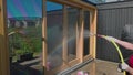 Slow motion. Woman spooling windows with water before washing them.