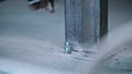 Slow-motioned closeup of the dirty hand of a worker striking a bolt with hammer