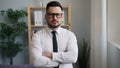 Slow moton portrait of serious businessman with crossed arms in office