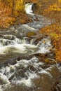 slow shutter speed waterfall flowing to creek over rock ledges in Fall
