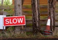 SLOW traffic sign with broken orange and white traffic cones