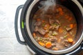 slowcooker with beef stew simmering, top view steam visible