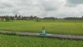 Slowmotion aerial shot of a young woman doing meditation for Muladhara chakra in a Balinese way