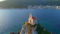 Slowmotion aerial video. The Sveta Nedelja - Christian church on a tiny island in the sea close to the city of Petrovac