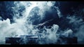 Slowmotion footage of a DJ making an epic buildup on a mixer with wispy clouds of smoke rising and dissipating around Royalty Free Stock Photo