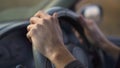 Slowmotion shot of hands of a mand riving a car on a car travel