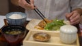 Slowmotion shot of a young man eatimg asian food in japanese-korean cafe