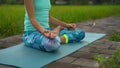 Slowmotion steadicam shot of a young woman doing meditation for Muladhara chakra in a Balinese way