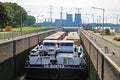 Cargo ship in water lock chamber during upward sluices at river Maas