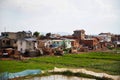 slum houses in the background and bright green rice fields. Traditionally