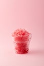 Slushie or Slush - drink on pink background. Fruit shaved ice in disposable plastic cup. Take away food. Refreshing summer drink. Royalty Free Stock Photo