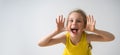 Sly happy preschool girl in sunny yellow dress teasing someone, yelling and laughing with a funny face. Close up studio Royalty Free Stock Photo