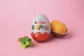 Slynchev Bryag, Bulgaria - May 25, 2023: Kinder Surprise Eggs, plastic capsule and toy turtle on pink background