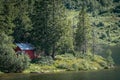 Smal red cottage inside the forest close to the lake Royalty Free Stock Photo