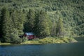 Smal red cottage inside the forest close to the lake Royalty Free Stock Photo
