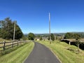 Smalden lane, with grass verges, old buildings and distant hills in, Grindleton, Clitheroe, UK