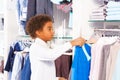 Small African boy in white shirts choosing clothes