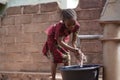 Small African Girl Washing Her Hands At The Village Well