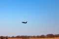 A small aircraft for the transport of passengers and parachutists takes off from the runway into the field and flies into the blue Royalty Free Stock Photo