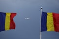 Small airplane between two Romanian flags