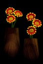 Small daisy flowers in two brown vases on black background Royalty Free Stock Photo