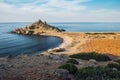 Small Alagadi beach panorama with peninsula and dry pasture with grazing sheep