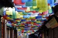 A small alley in Boudhanath, Kathmandu, is filled with colorful Tibetan prayer flags