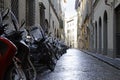 Small alley with a row of parked motorcycles in Florence, Italy Royalty Free Stock Photo