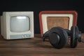 A small antique TV, radio and headphones on a wooden table. Royalty Free Stock Photo