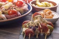 Small appetizers on skewers on wooden table