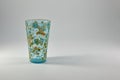 A small aquamarine Antique Glass, Vase or water Beaker with a depiction of a Honey Bee on flowers in Enamel with Gold Gilt. Royalty Free Stock Photo