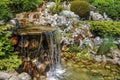 Small artificial waterfall in man made tropical garden Royalty Free Stock Photo