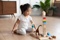 Small asian baby girl playing with cubes alone at home.