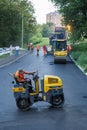 Small asphalt paver roller in road works